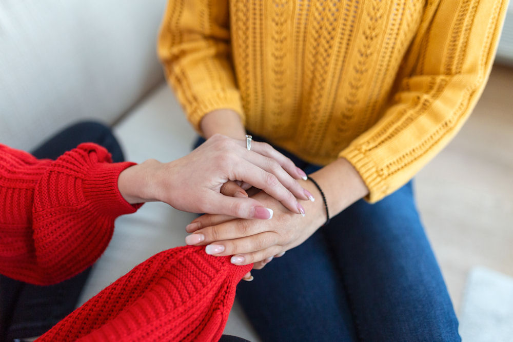 women holding hands during therapy