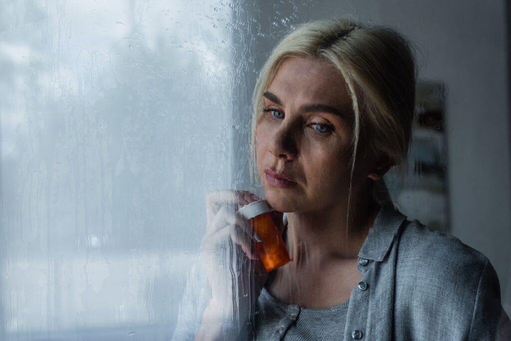 a woman holding a pill bottle of Amoxicillin